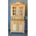 A Pine Side Cabinet, the moulded shaped cornice above two bar glazed doors raised upon shaped