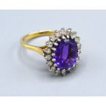 An 18ct Yellow Gold Amethyst And Diamond Set Ring with large central oval amethyst surrounded by