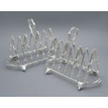 A Pair Of Silver Plated Six Division Toast Racks in the form of riding crops, the feet in the form