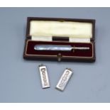 A London Silver Model Of A Cricket Bat Within Fitted Case together with two silver ingot pendants