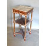 A French Mahogany Etagere, the variegated marble top above a frieze drawer and two under tiers