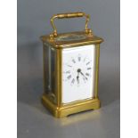 A Brass Cased Carriage Clock with lever escapement, carrying handle and enamel dial with Roman and