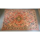 A North West Persian Woollen Rug with an all over design upon a red, blue and cream ground within