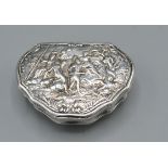 An 18th/19th Century Dutch White Metal Tobacco Box of shaped form, the hinged cover decorated in