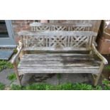 A Pair of Teak Garden Benches each with a triple lattice work back above a slated seat raised upon