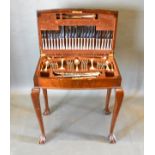 A Silver Plated Canteen Of Cutlery housed within a walnut canteen cabinet raised upon cabriole