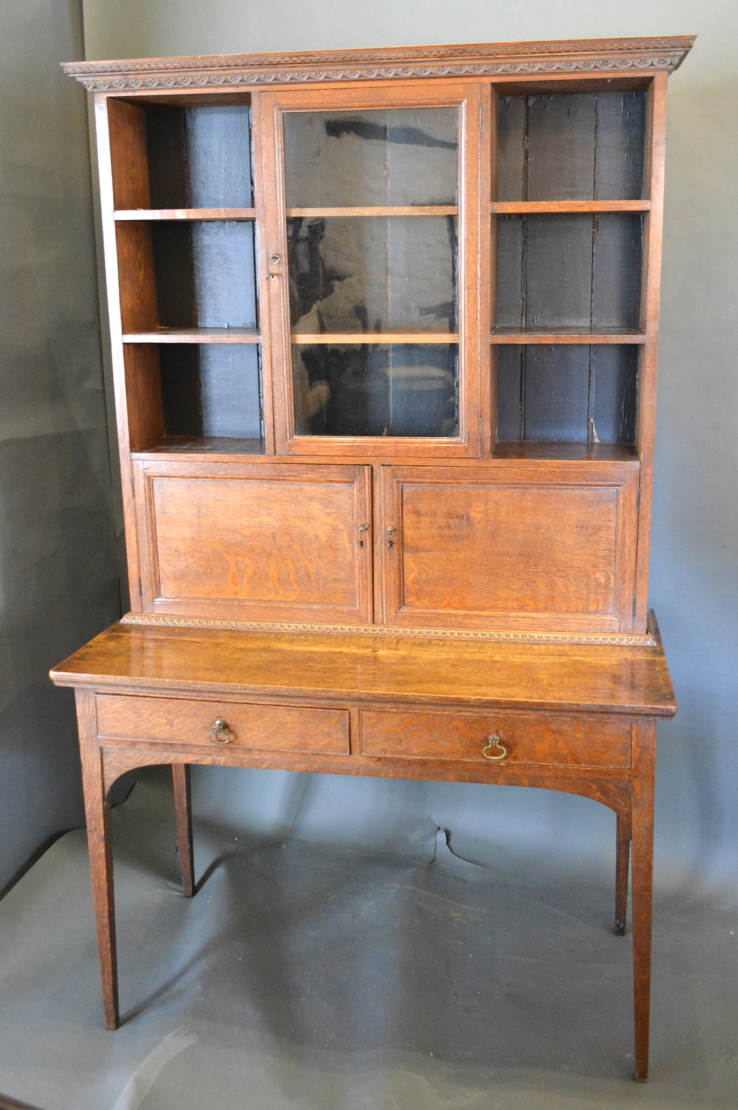 An Early 20th Century Oak Dresser, the moulded cornice above a central glazed door flanked by