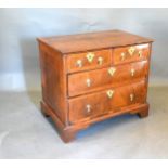 An 18th Century Walnut Chest, the line inlaid quarter veneered top above two short and two long