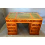 A Twin Pedestal Desk, the tooled leather inset top above nine drawers with brass handles, raised