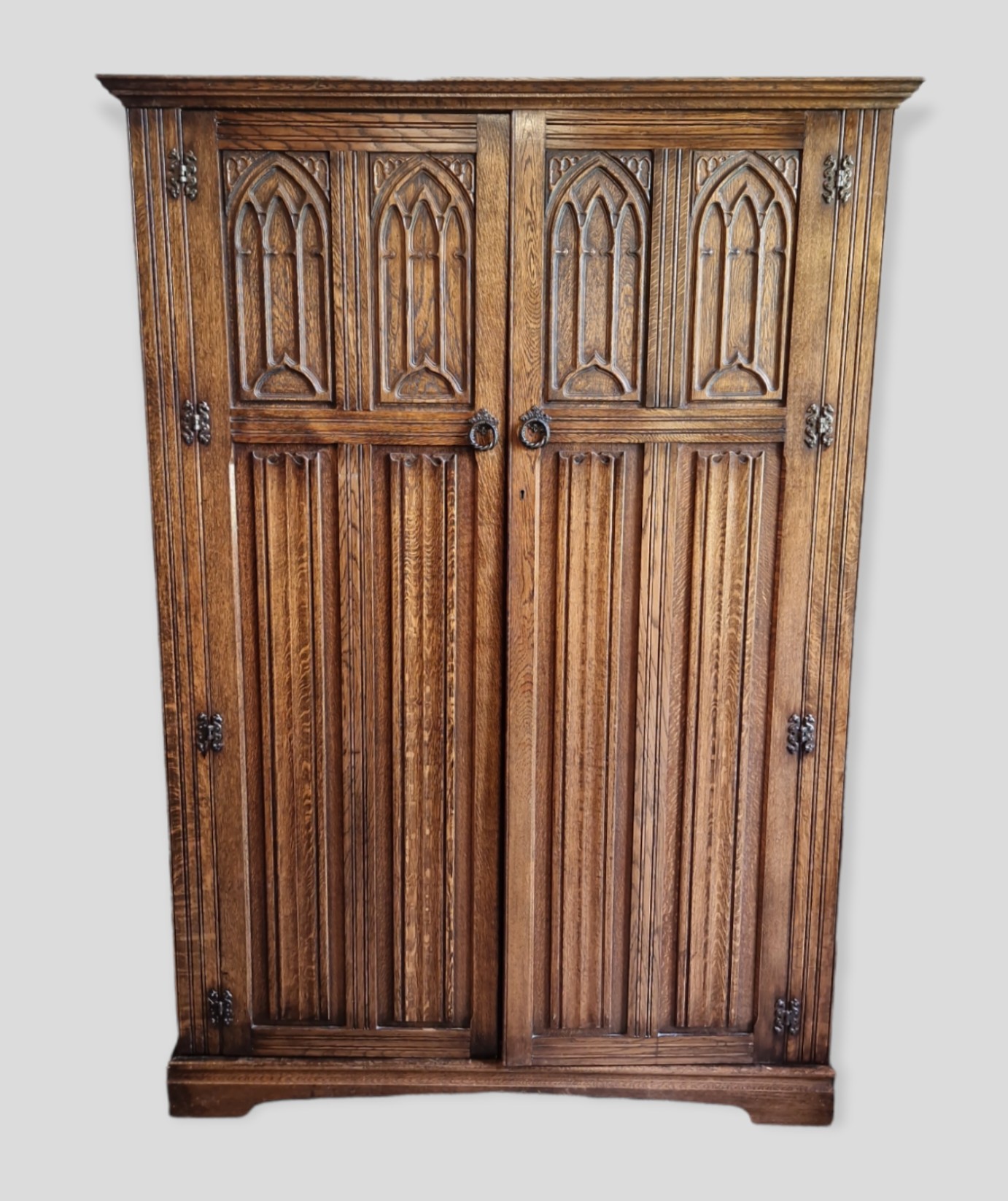 An Oak Gothic Revival Bedroom Suite comprising six drawer chest, dressing table, wardrobe and two