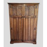 An Oak Gothic Revival Bedroom Suite comprising six drawer chest, dressing table, wardrobe and two