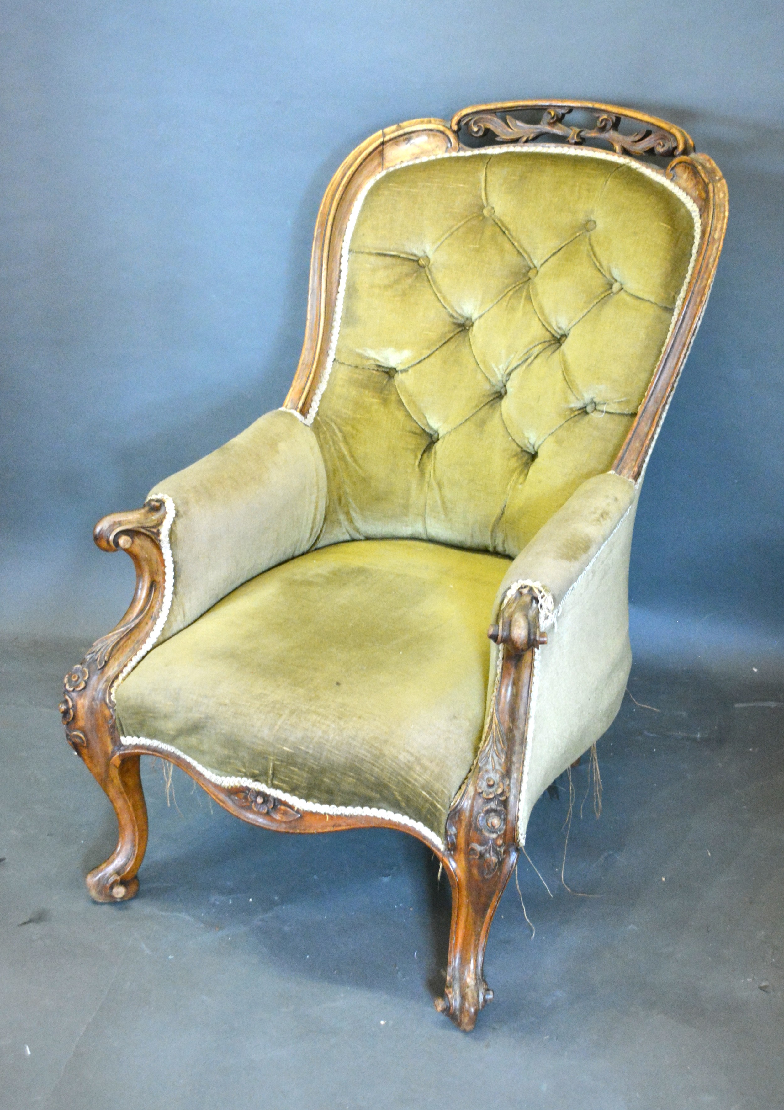 A Victorian Walnut Drawing Room Armchair, the button upholstered back above a stuff over seat raised