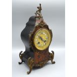 A 19th Century Boulle and Gilt Metal Mounted Mantle Clock of shaped form, the gilt dial with Roman