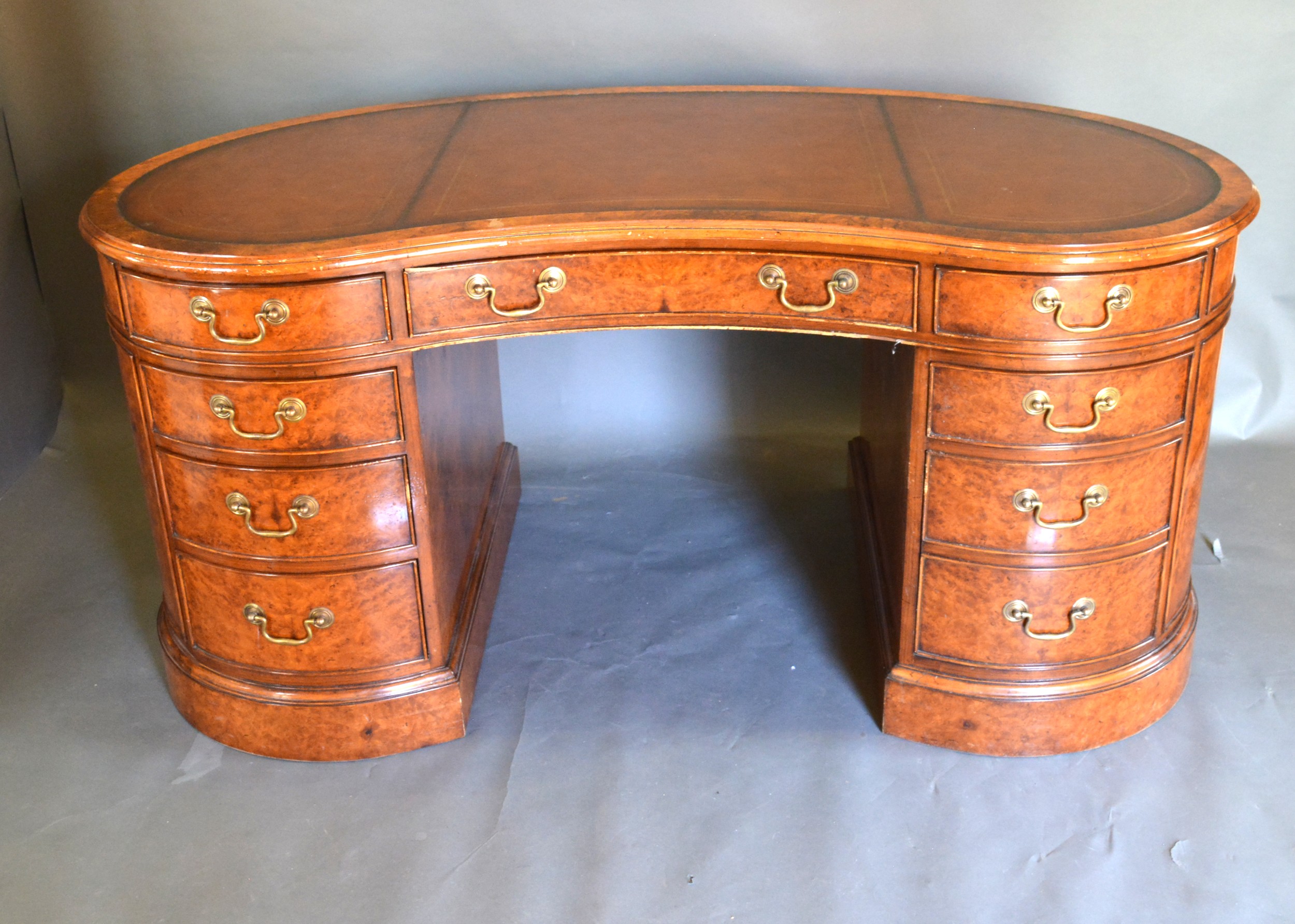A Burr Walnut Kidney Shaped Twin Pedestal Desk, the tooled leather inset top above nine drawers with