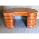 A Burr Walnut Kidney Shaped Twin Pedestal Desk, the tooled leather inset top above nine drawers with