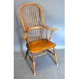 A 19th Century Elm Windsor Armchair with a stick back above a panel seat raised upon turned legs