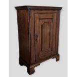 A 19th Century Oak Side Cabinet, the moulded top above a panelled door raised upon bracket feet,