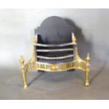 A Regency Style Iron Steel and Brass Fire Basket of shaped form with brass finials 61 cms wide, 29