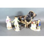 A Nymphenburg Porcelain Model Of A Dog together with a German porcelain group and two similar