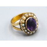 An 18ct. Gold Amethyst And Pearl Set Ring with a central amethyst surrounded by pearls, 7.4gms. ring
