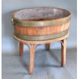 A Wine Cooler Of Oval Barrel Form with end handles, raised upon square legs with corner mounts, 62 x