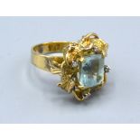A Yellow Metal Dress Ring set with a rectangular aquamarine and four diamonds within a pierced