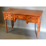 A 19th Century Mahogany Side Table with three drawers and a cupboard door raised upon ring turned