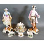 A pair of porcelain continental figures together with a chocolate cup saucer and cover and three