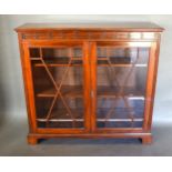 An Edwardian Mahogany Dwarf Bookcase, the moulded top above two glazed doors enclosing shelves