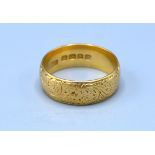 An 18ct. Gold Engraved Wedding Band 6.1 gms