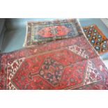 A North West Persian Woollen Rug with a central medallion within an all over design upon a red, blue