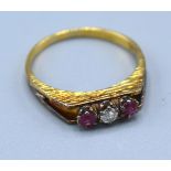 An 18ct Yellow Gold Ruby And Diamond Ring set with central diamond flanked by two rubies within a