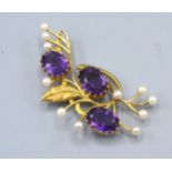 A 9ct. Gold Amethyst And Pearl Set Brooch of foliate spray form, 6.5cms long, 16.6gms.