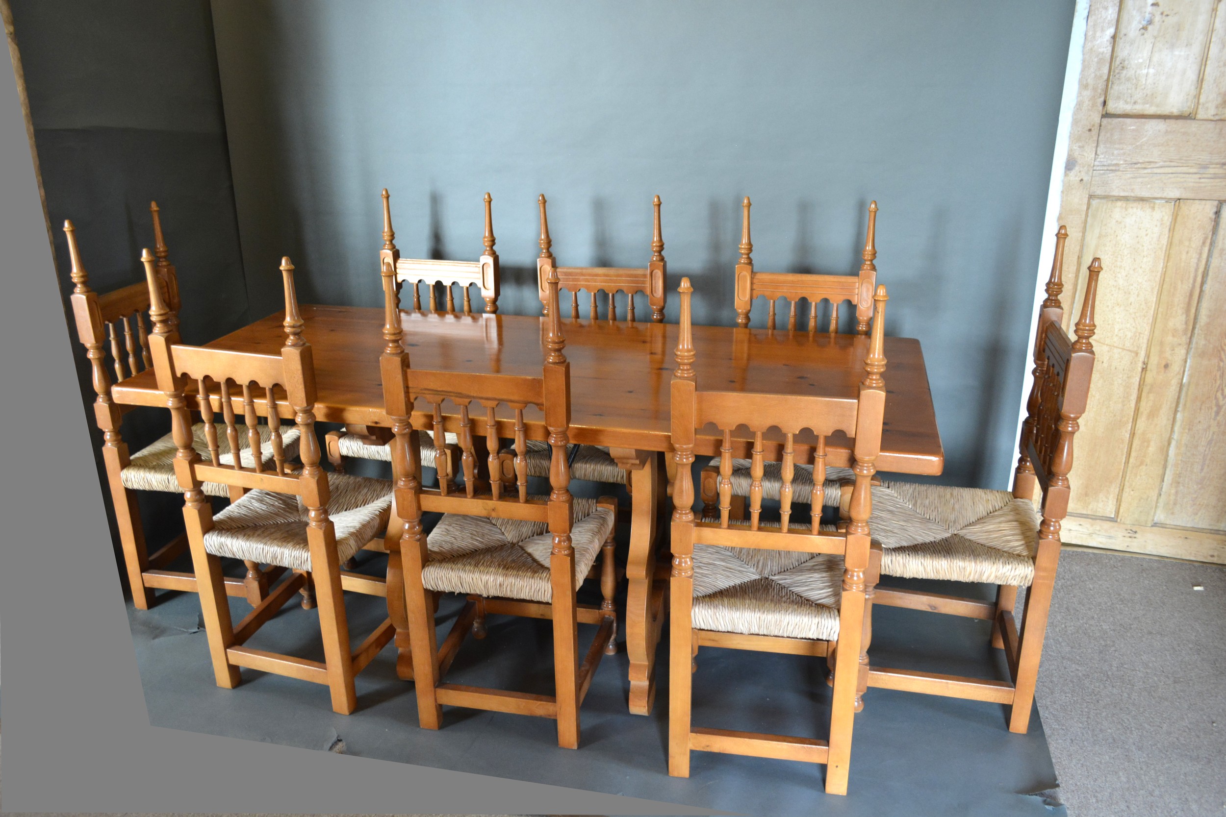 A Spanish Pine Refectory Style Dining Table together with a set of eight spindle back chairs, 182cms