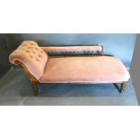 A Victorian Chaise Longue with a button upholstered scroll end raised upon turned legs