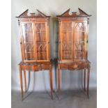A Pair Of Mahogany Sheraton Revival Cabinets On Stands each with a moulded pediment above arched,