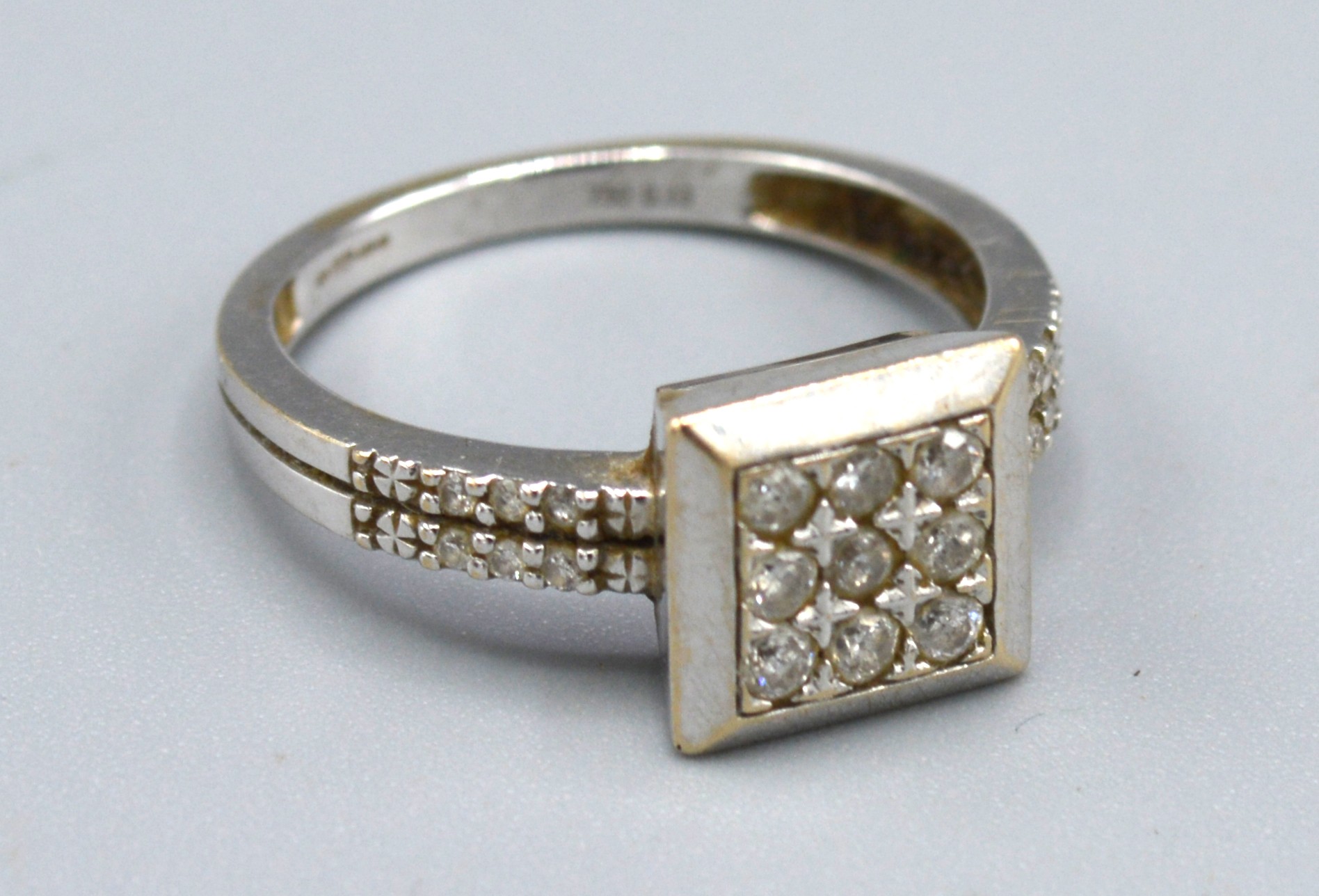 An 18ct. White Gold Square Set Diamond Ring, 3.4gms. ring size M