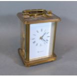 A brass cased carriage clock with lever escapement and carrying handle