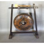A Burmese Bronze Gong with gilded decoration and depicting figures upon a hard wood stand, the