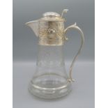 A silver plated and engraved glass claret jug, 24cms tall