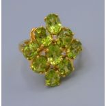 A dress ring set with nine peridot within a pierced setting, ring size O