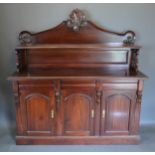 A mahogany sideboard, the shaped carved back with shelf, the lower section with three drawers
