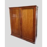 A Late Victorian Mahogany Dwarf Wardrobe, the moulded top above two panel doors enclosing sliding