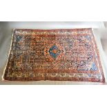 A North West Persian Woollen Rug with a central medallion with an all over design upon a blue, cream