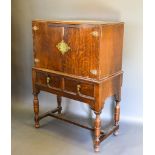 An Oak Cabinet On Stand with two doors above two moulded drawers raised upon turned legs with