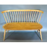 An Ercol Bench Seat with spindle back above a shaped seat raised upon turned legs with stretcher 113