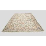 A Hand Made Woollen Carpet with an all over design upon a cream ground within multiple borders,