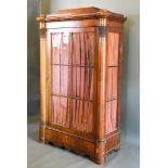 A 19th Century Beidermeier Cabinet, the moulded top above a fabric pleated and bow glazed door