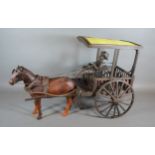 A wooden model in the form of a hose and cart with figure, 52cms long
