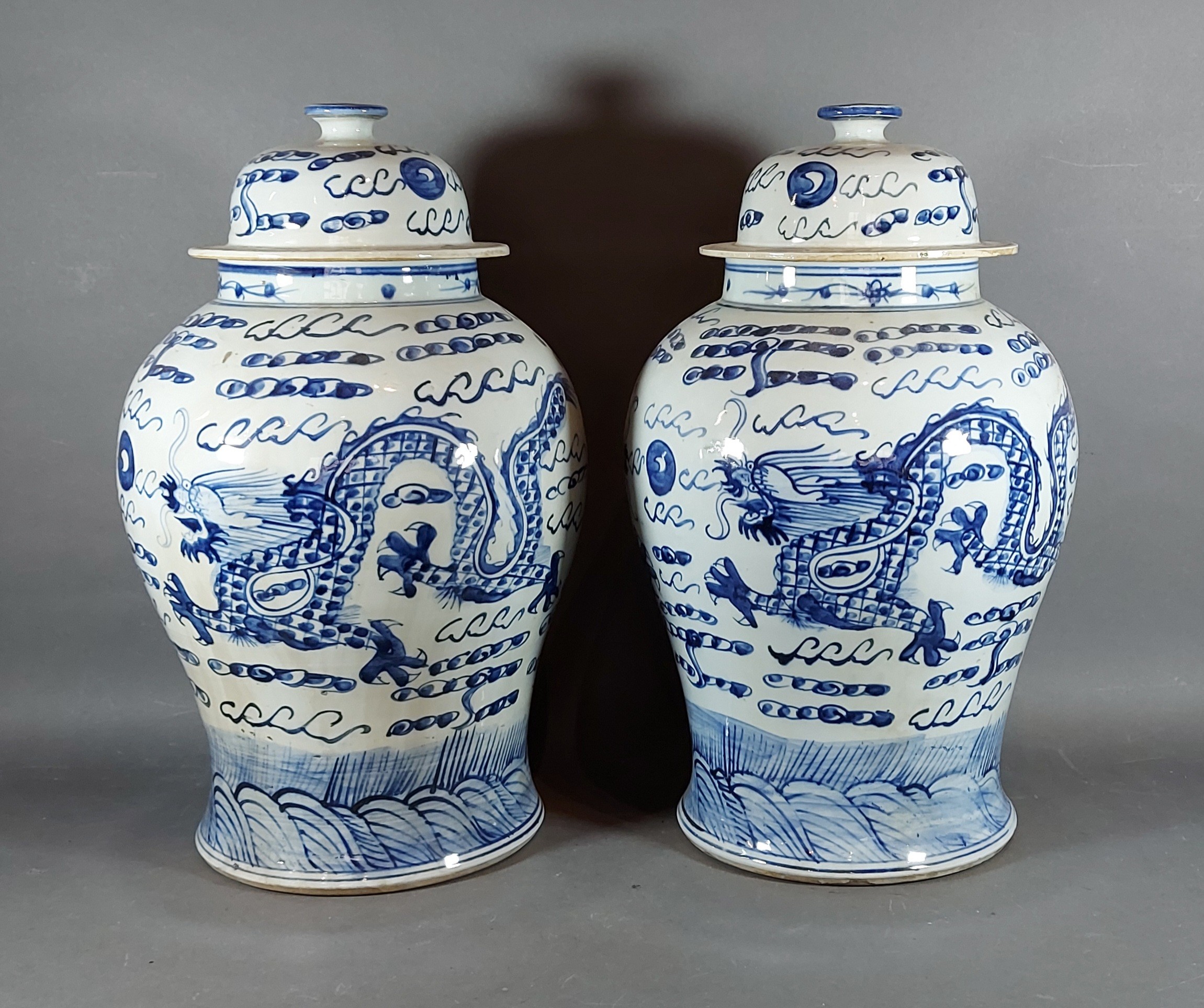 A pair of Chinese blue and white large covered vases, each decorated with serpents in underglaze